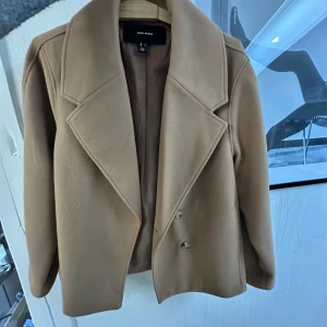 Beige/brun kappa  - Snygg beige/brun kappa från Vero Moda med breda slag och dubbelknäppning. Perfekt för höst och vår. Klassisk design som passar till många olika stilar. Jättefint skick 