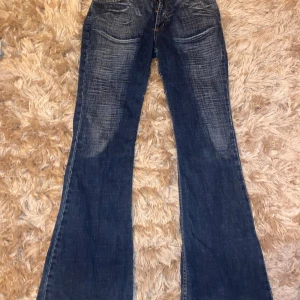 Blå bootcut jeans från Fedex Jeans - Snygga blå bootcut jeans från Fedex Jeans med klassisk femficksdesign. Jeansen har en lätt tvättad look och stängs med dragkedja och knapp. kontakta mig för några frågor! midrise och som nytt skick. pris kan diskuteras.