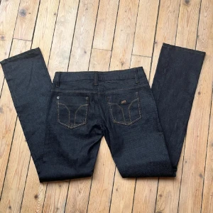 Svarta jeansbyxor - Säljer ett par snygga mörkblå/svarta jeansbyxor. De har en klassisk design med raka ben och fem fickor. Perfekta för både vardag och fest!