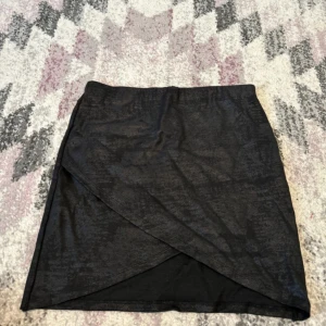 Kjol - En fin svart kjol som passar med flera toppar, från Gina tricot, storlek M