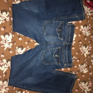 Blå jeans med fickdetaljer - JÄTTESNYGGA GINATRICOT JEANSS!!😻I jättebra skick och har super fina detaljer på fickorna!😻😻De är lowaist och är bootcut jättesnygga men jätteenkla som man kan ha hur många gånger som helst!!❤️Midjemått: Ca 31 cm rakt över❤️❤️ Innerbenslängd: Ca 75 cm