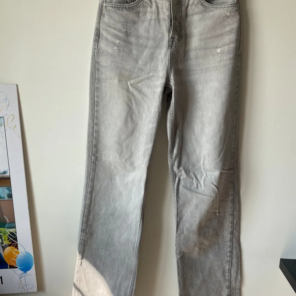 Säljer ett par snygga grå jeans från Zara i storlek XS. De har en klassisk straight fit och är tillverkade i ett slitstarkt denimtyg. Byxorna har knappar i gylfen och två bakfickor. Perfekta för både vardag och fest!. Jeans & Byxor.