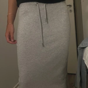Grå ribbad kjol - Fin kjol i tunnt material, ribbad i lagom längd. Gott skick🖤