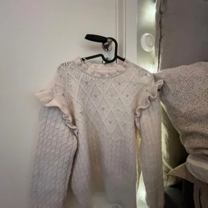 stickad tröja med glitter och berlocker på - från primark, väldigt fint skick då den aldrig är använd