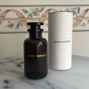 Ombre Nomade Parfym från Louis Vuitton - Säljer en lyxig och mystisk parfym, Ombre Nomade från Louis Vuitton. Doften är en intensiv blandning av oudträ, benzoin, rökelse och hallon, perfekt för den som älskar unika och djupa dofter.