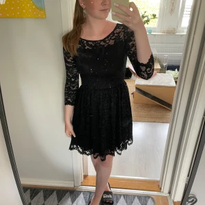 Svart spetsklänning - Säljer en elegant svart spetsklänning med trekvartsärm. Klänningen har en vacker spetsdesign och en tight passform som ger en stilren look. Den är även nästan aldrig använd och är Perfekt för festliga tillfällen! 💓