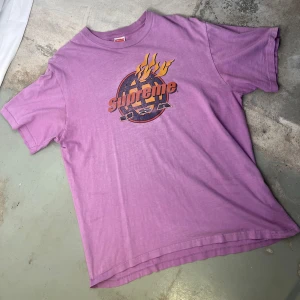 Supreme - Retro Tee - Häftig lila retro t-shirt med tryck framtill.  Material 100% Bomull  Made in USA  *Trycket något slitet. 