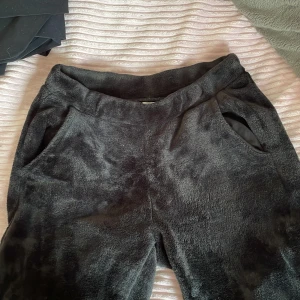 Svarta mjukisbyxor i fleece - Säljer ett par supermysiga svarta mjukisbyxor i fleece. Perfekta för kalla dagar när du bara vill chilla hemma. De har en normal passform och är riktigt mjuka och sköna. Byxorna har fickor på sidorna och en elastisk midja för extra komfort. Perfekta för höst och vinter! aldrig använda!! nypris: 399kr