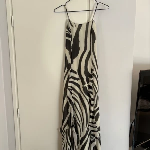 Maxiklänning i zebramönster, H&M - Otrolig långklänning med slitsdetalj i zebramönster från H&M, aldrig använd, lappen kvar 🥰 djup rygg med knytdetalj. Storlek XS, normal i storleken! Nypris 599kr  Sista bilden är en liknande klänning! 