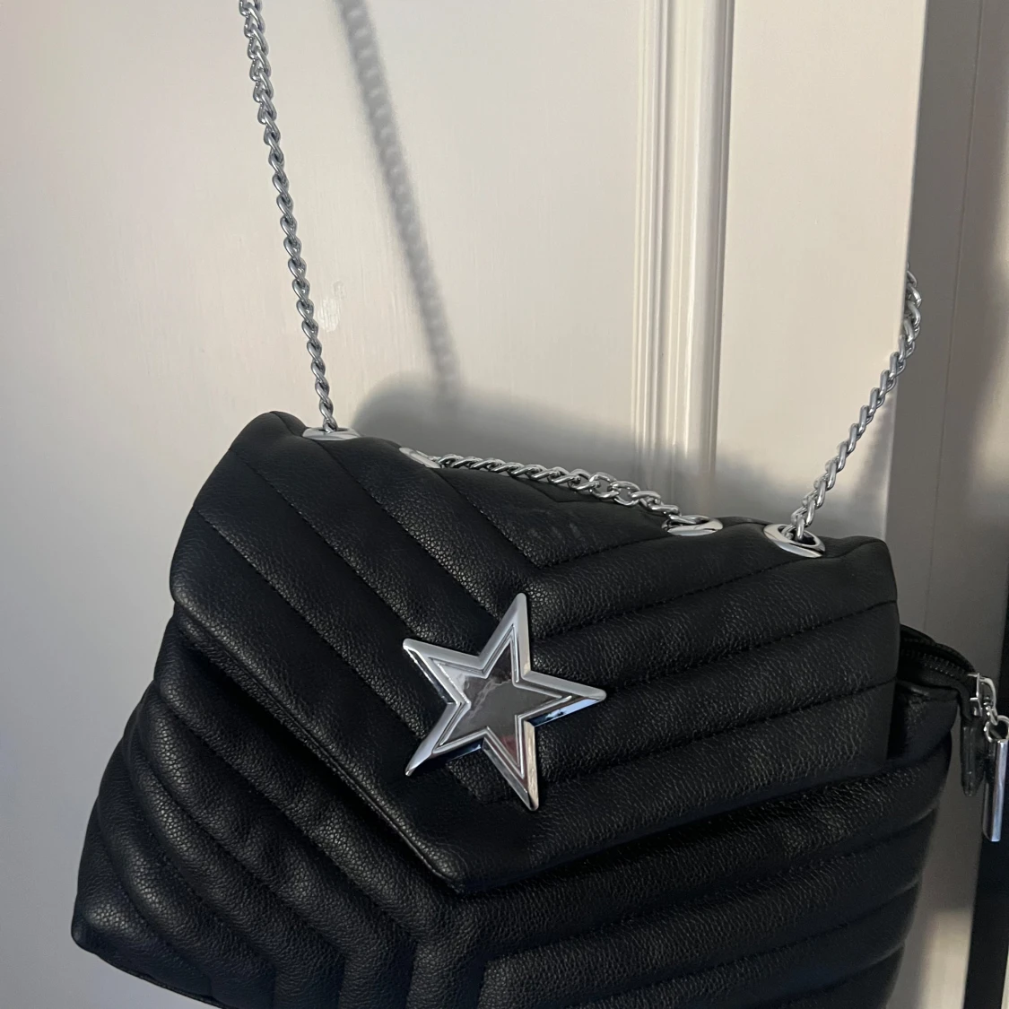 Svart quiltad axelväska med stjärndetalj