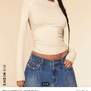 Beige långärmad topp från Shein - Trendig beige topp från Shein med långärmade och en öppen rygg. Perfekt för en stilren look med en twist. Toppen har en tight passform och är tillverkad i ett mjukt material.