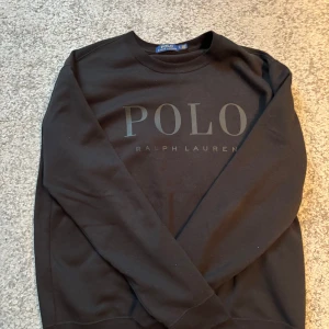 Svart tröja från Ralph Lauren - Snygg svart tröja från Ralph Lauren med stort POLO-tryck på framsidan. Storlek L, skriv om du är intresserad!