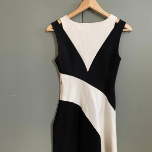 Svart och vit klänning från Karen Millen - Snygg svart och vit klänning från Karen Millen med ett unikt geometriskt mönster. ❤️🤩Klänningen är ärmlös och har en elegant design som passar perfekt för speciella tillfällen. Den är i storlek EU 34 och har en stilren look.