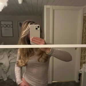 Beige långärmad tröja från Intimissimi - Säljer en mjuk och bekväm beige tröja från Intimissimi, tillverkad i en blandning av viskos och kashmir. Tröjan har långa ärmar och en klassisk passform, perfekt för kyligare dagar. Ett stilrent plagg som passar till många olika outfits.