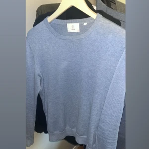 Blå tröja från bläck  - Säljer en stilren blå tröja från bläck. Tröjan har en klassisk rund hals och långa ärmar, perfekt för en avslappnad look. Den är tillverkad i ett mjukt material som känns skönt mot huden.