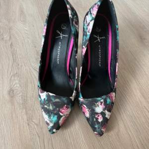 Snygga pumps med blommigt mönster i rosa och gröna nyanser från Primark. Skorna har en spetsig tå och hög klack, vilket ger en elegant look. Perfekta för att sätta färg på din outfit.