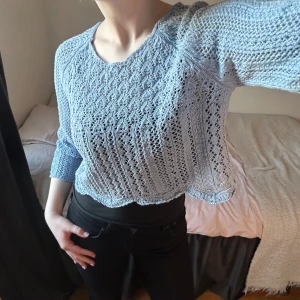 Ljusblå stickad tröja - Säljer en ljusblå stickad tröja med ett fint hålmönster. Croppad tröja i storlek S, men skulle säkert passa även en XS eller en M. Använd ett fåtal gånger, mycket bra skick utan defekter. 