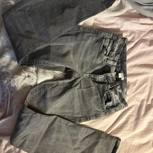 Grå jeans från Gina Tricot - Snygga grå jeans från Gina Tricot med dekorativa bakfickor. De har en klassisk femficksdesign och en bekväm passform. Perfekta för en stilren look.