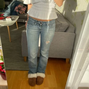Low waist bootcut jeans med hål - SÅ snygga jeans med hål!! OBS, nytt hål vid knät har tillkommit som inte syns på de första 4a bilderna, men som finns på 5e bilden ❤️Midja: 37cm, innerbenslängd: 80cm, har blivit lagade