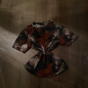 Camouflage t-shirt från lager 157 - Snygg t-shirt från lager 157 med ett unikt camouflage-mönster i jordnära färger som brunt, svart och beige. Perfekt för en avslappnad stil. Tillverkad i mjukt material för extra komfort.