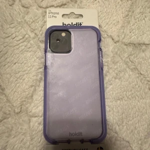Fodral för iPhone 11 Pro från Holdit och Ideal of Sweden - Säljer tre snygga mobilskal för iPhone 11 Pro, iPhone 11 och iPhone 14 PRO. Ett lila skal med genomskinlig baksida från Holdit (iPhone 11 PRO) ett orange silikonfodral från Holdit (iPhone 11) och ett färgglatt skal med texten 'Good Vibes' i grönt och rosa från Ideal of Sweden (iPhone 14 PRO) alla skal för 99 kr eller ett för 39 kr. Skriv till mig om du enbart önskar ett utan skalen.