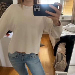Vit stickad tröja från Zara - Säljer en stilren vit stickad tröja från Zara. Tröjan har en rund halsringning och långa ärmar, perfekt för en avslappnad look. Passar bra till jeans eller kjol. Perfekt för kyligare dagar!