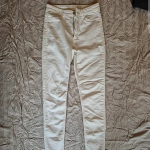 Vita skinny jeans - Snygga vita skinny jeans med hög midja. Perfekta för en stilren look. De har en dragkedja och knapp framtill samt fickor bak.
