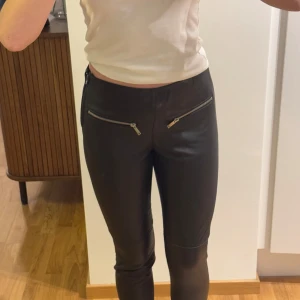 Svarta skinnbyxor från Ellos - Aldrig använt då de är lite korta på mig som är 169 cm lång. Obs! äkta fårskinn!! Köpte för 2100kr