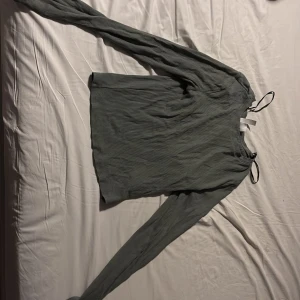 Grön ribbad långärmad topp - Säljer en stilren grön ribbad topp med långa ärmar. Perfekt för en avslappnad look. Toppen har en enkel design och är lätt att matcha med olika outfits.