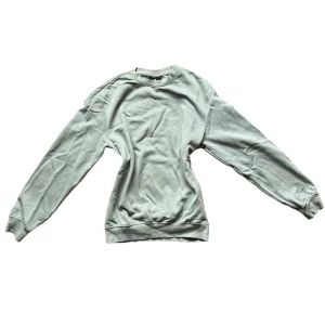 Grå/grön sweatshirt från H&M - Säljer en grön/grå sweatshirt från H&M. Den har en avslappnad passform. Tröjan är långärmad och har ribbade muddar vid ärmslut och nederkant. Köpt på herravdelningen men funkar även till damer. Varan är använd och nopprig. Storlek: XS