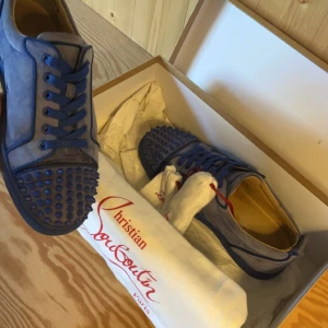 Louboutin skor - Säljer nu ett par riktigt feta Louboutin skor i färgen ljusblå. Skicket är bra förutom två små skador i skorna som ni kan se på bilderna. Man får med box, dustbag, nitar samt extra snören.