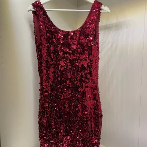 Röd paljettklänning från Model Behaviour - Säljer en superglittrig röd paljettklänning från Model Behaviour. Den är ärmlös och perfekt för festliga tillfällen. Klänningen har en tight passform och är i storlek S. Perfekt för att glänsa på nyår eller en annan festlig kväll! ✨