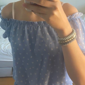 Blå blus med vita blommor💙🦋🤍 - Jätte bra skick och är bara använd ett par gånger, säljs för att den är för liten. Den går både att ha vanligt och off shoulder. Materialet är väldigt skönt och luftigt 