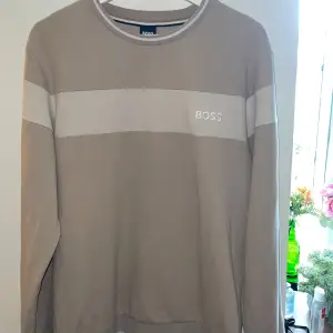 Oanvänd Boss tröja i beige med BOSS broderat i vitt på vänster bröst.  Den är en del av ett set (byxorna är använda med något hål i)  Köpt på Zalando för 2-3 år sedan Storlek: M 