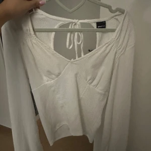 Festlig tröja från Gina Tricot  - En ursnygg blus från Gina Tricot med öppen rygg samt en rosett. Den sitter super fint på en. Storlek S Den är i toppen skick och knappt använd. Passar perfekt till ett par kostymbyxor 