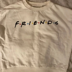 Vit sweatshirt från Pull&Bear med FRIENDS-tryck - Säljer en superfin creamvit sweatshirt från Pull&Bear med FRIENDS-tryck på framsidan. Tröjan är i storlek XS och väldigt bra skick.😍Den är gjord av mjuk bomull och har långa ärmar samt ribbade muddar vid ärmslut och nederkant. Använda ca 2 gånger. Perfekt både hemma och ute-på!✨💞