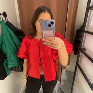 Röd blus med knytband - Säljer denna snygga röda toppen från Gina Tricot i storlek XS💕 säljer den då den inte kommer till användning, bara använd en gång! Säljer den för 275kr+ frakt, då jag köpte den för 499kr💕