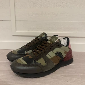 Valentino Rockrunners  -  Valentino Rockrunner med ett  camouflagemönster i gröna och bruna toner. Skorna har rosa röda detaljer på hälen, storlek:42 men passar mig som har 43. Slitage på ena skon längst fram vid tårna.