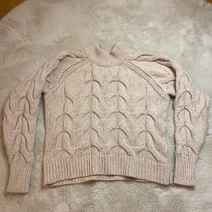 Beige stickad tröja från Object - Säljer en snygg beige stickad tröja från Object med ett flätat mönster. Tröjan har långa ärmar och ribbade muddar vid ärmslut och nederkant. Perfekt för kyliga dagar! Tajt krage. Ganska använd men bra skick ändå! Frakt ingår ingår inte!!