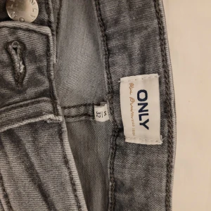 Grå bootcut jeans från ONLY - Snygga grå lågmidjade bootcut jeans från ONLY i storlek M, passar mig perfekt som e 170 lång och brukar bära storlek S De har en klassisk femficksdesign och en bekväm passform. Perfekta för en avslappnad stil.