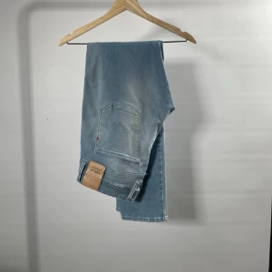 Ljusblå jeans från Replay - Snygga ljusblå jeans från Replay med en modern slim passform. De har klassiska fem fickor och en dragkedja. Perfekta för en avslappnad stil. Storlek är w33 L32. Jeansen är hyper flex!!