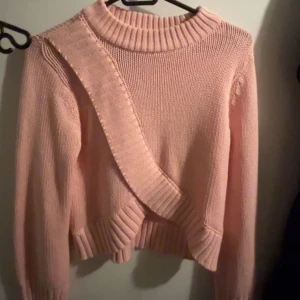 Rosa stickad tröja från Gina Tricot - Säljer en söt rosa stickad tröja från Gina Tricot. Tröjan har en ribbad krage och muddar, vilket ger en mysig känsla. Perfekt för kyligare dagar.