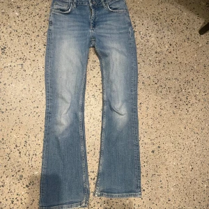 Blå bootcut jeans - Snygga blå bootcut jeans med en klassisk femficksdesign. De har en lätt tvättad look och är perfekta för en avslappnad stil. Passar bra till sneakers eller boots.