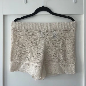 Beige spets shorts  - Snygga beige shorts i spets från H&M. Perfekta för sommardagar med sitt luftiga och stilrena mönster. De har en elastisk midja för extra komfort och en fin spetsdetalj vid fållen.