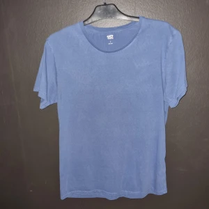 Blå t-shirt från 157 - Säljer en blå t-shirt från 157 i storlek L. Den är tillverkad av 100% bomull och har en klassisk rund halsringning. Perfekt för en avslappnad stil.