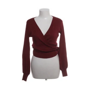 Vinröd omlott tröja från Gina Tricot - Snygg vinröd omlott tröja från Gina Tricot med v-ringning och långa ärmar. Perfekt för en stilren look. Tröjan har en ribbad struktur och är i en mjuk och bekväm kvalitet.sitter som xs❤️