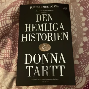 Den hemliga historien - Jubileumsutgåva av 'Den hemliga historien' av Donna Tartt. En fängslande roman med en mörk och mystisk berättelse. Perfekt för dig som älskar spänning och djupa karaktärsstudier.