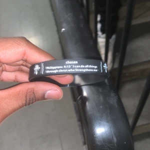 Svart armband med text - Svart armband med texten 'Philippians 4:13 I can do all things through Christ who strengthens me' och dekorerat med korsmotiv. Perfekt för daglig inspiration och stil.