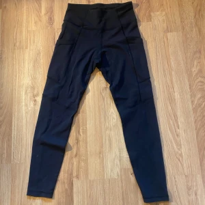 Svarta leggings från SOC - Säljer ett par svarta leggings från SOC i storlek S. De är högmidjade och har praktiska fickor på sidorna. Perfekta för träning med sin bekväma passform och stretchiga material.