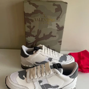 Valentino Garavani sneakers i vit och grå camouflage - Snygga Valentino Garavani sneakers med vit och grå camouflage-mönster. Skick 8/10 köptes här på plick, pris är inte bestämt så skicka pris förslag. Skriv om ni har frågor